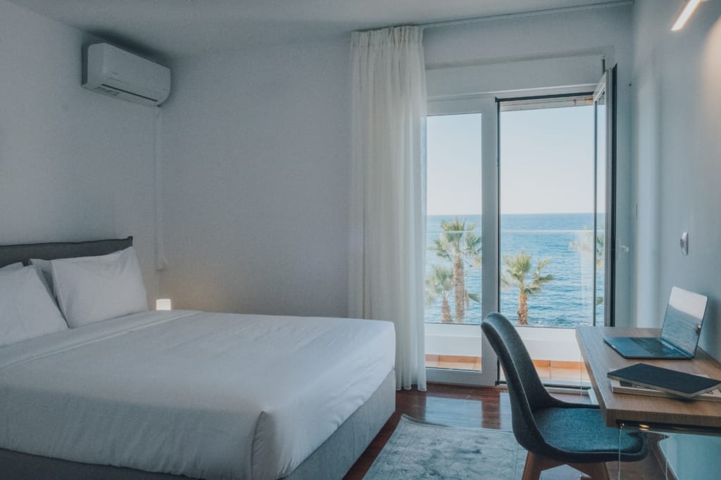 Bedroom with a desk and balcony doors opening onto the sea