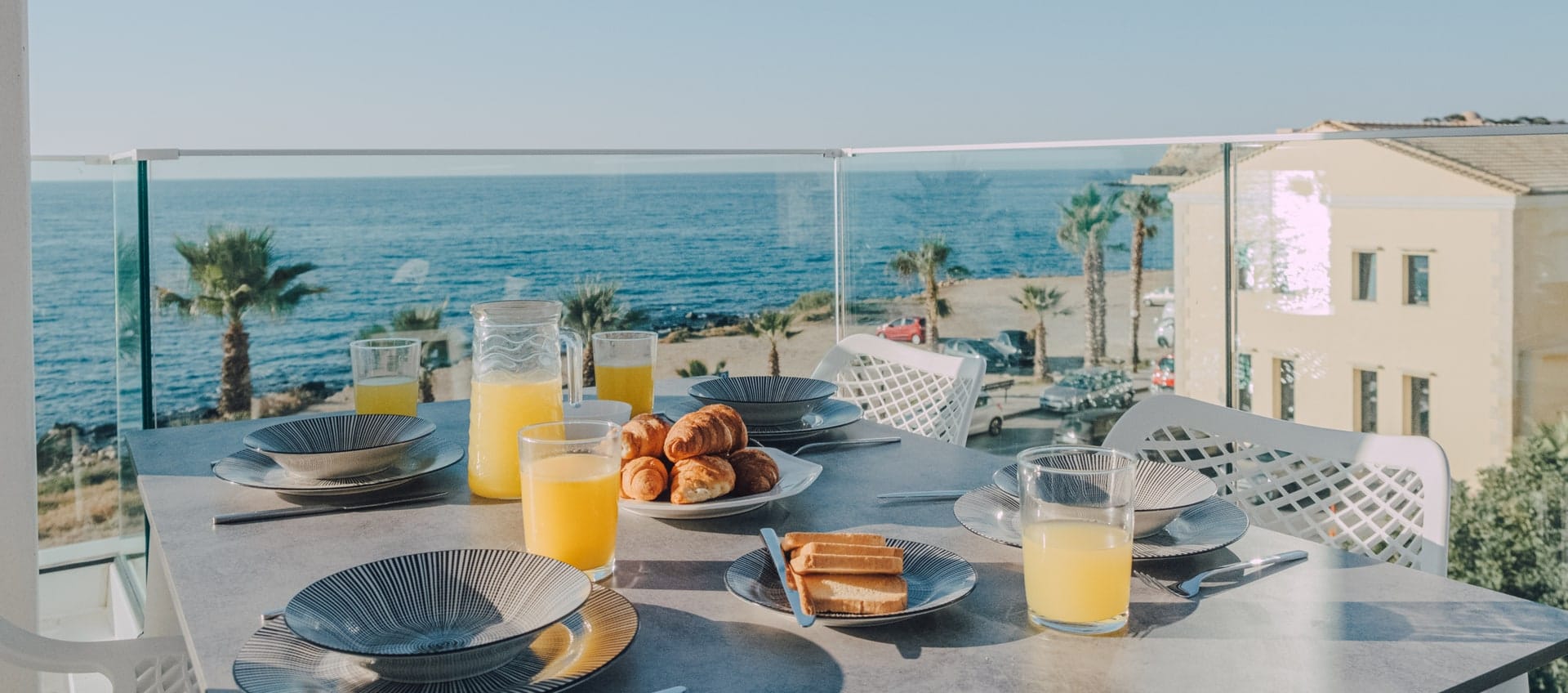 Breakfast laid on the balcony table overlooking the beach