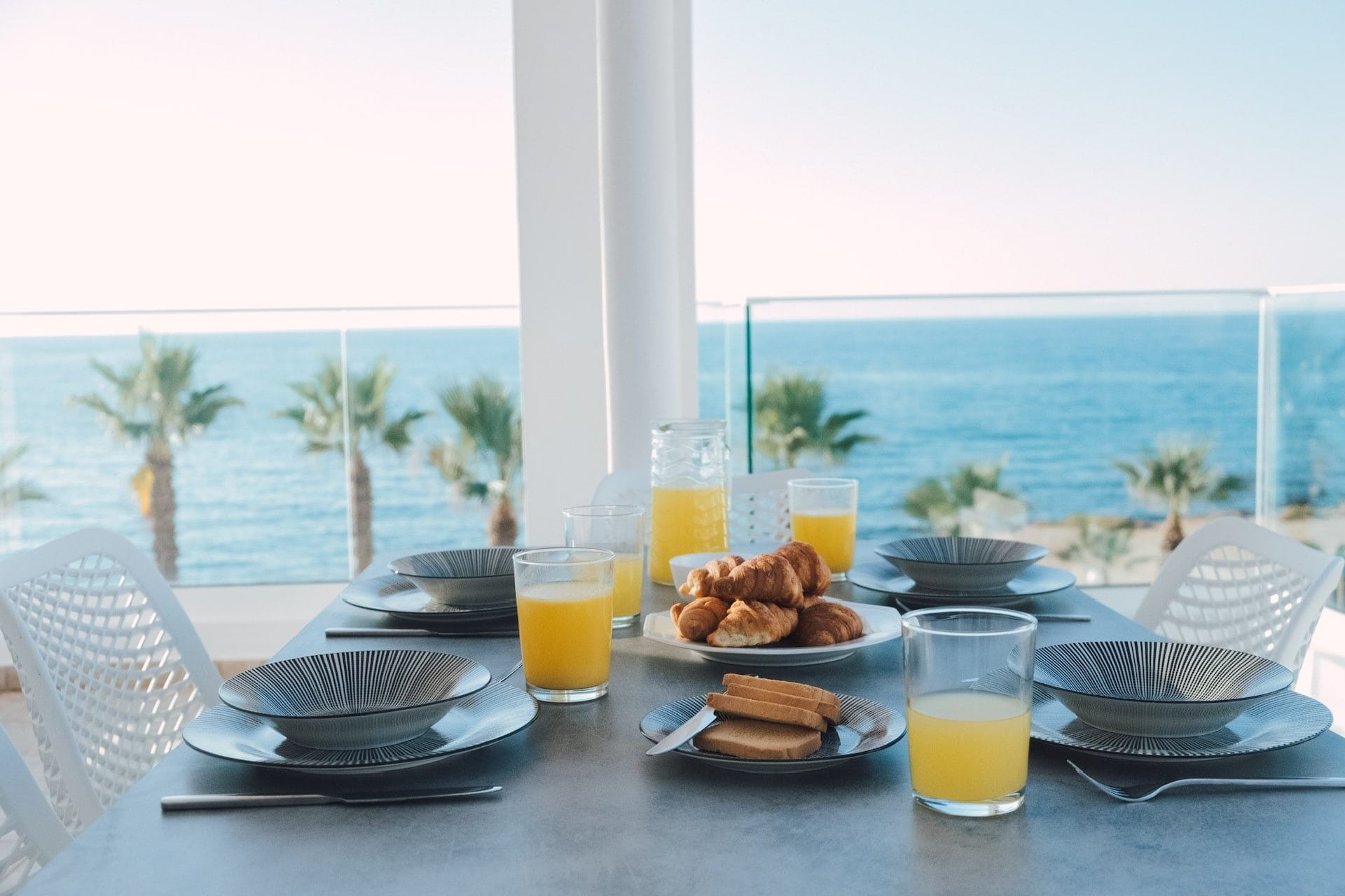 Table laid for breakfast on the balcony above the beach