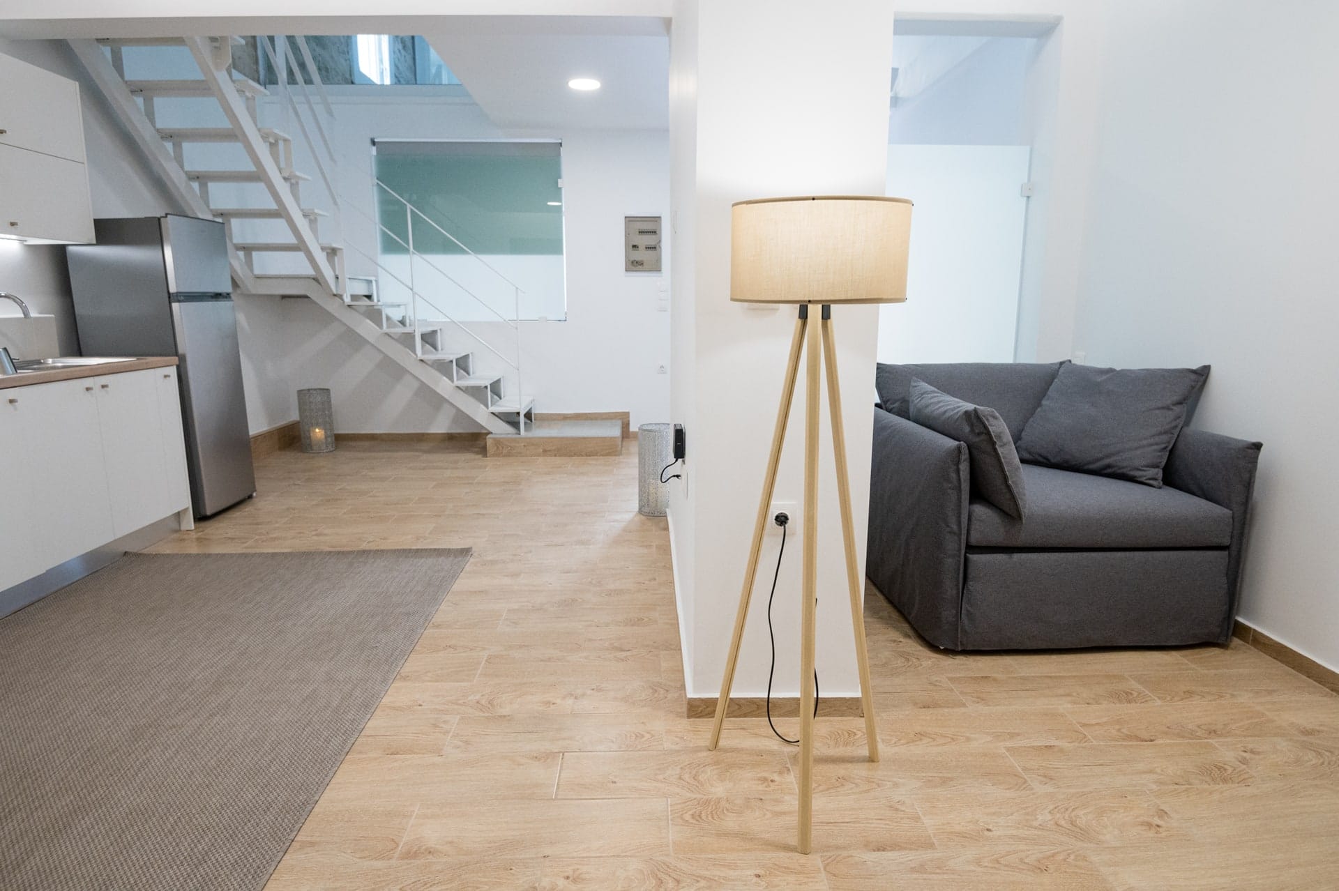 Living room with a corner sofa, floor lamp and the staircase