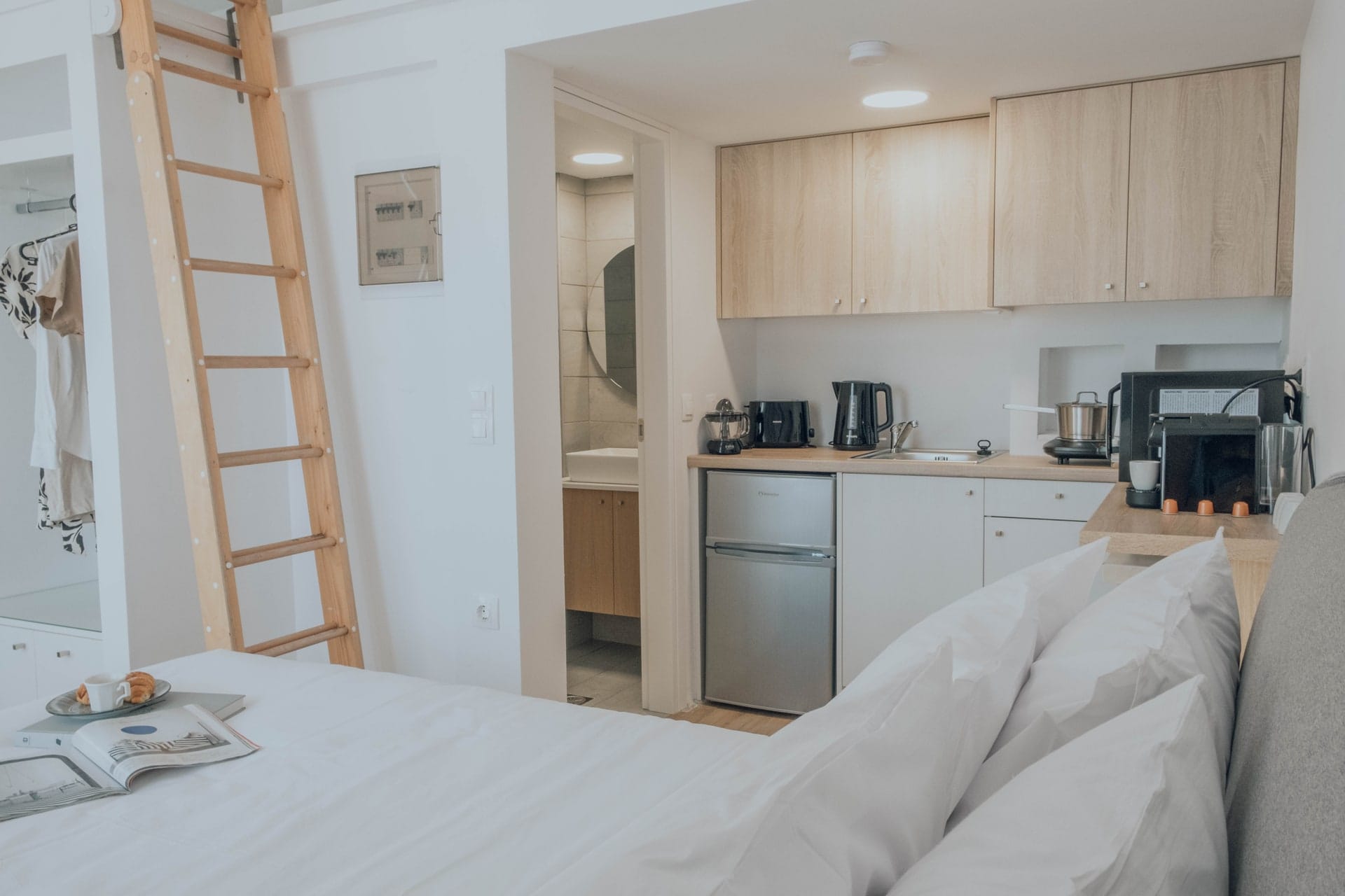 Studio interior with the ladder to the upper level and the kitchenette behind
