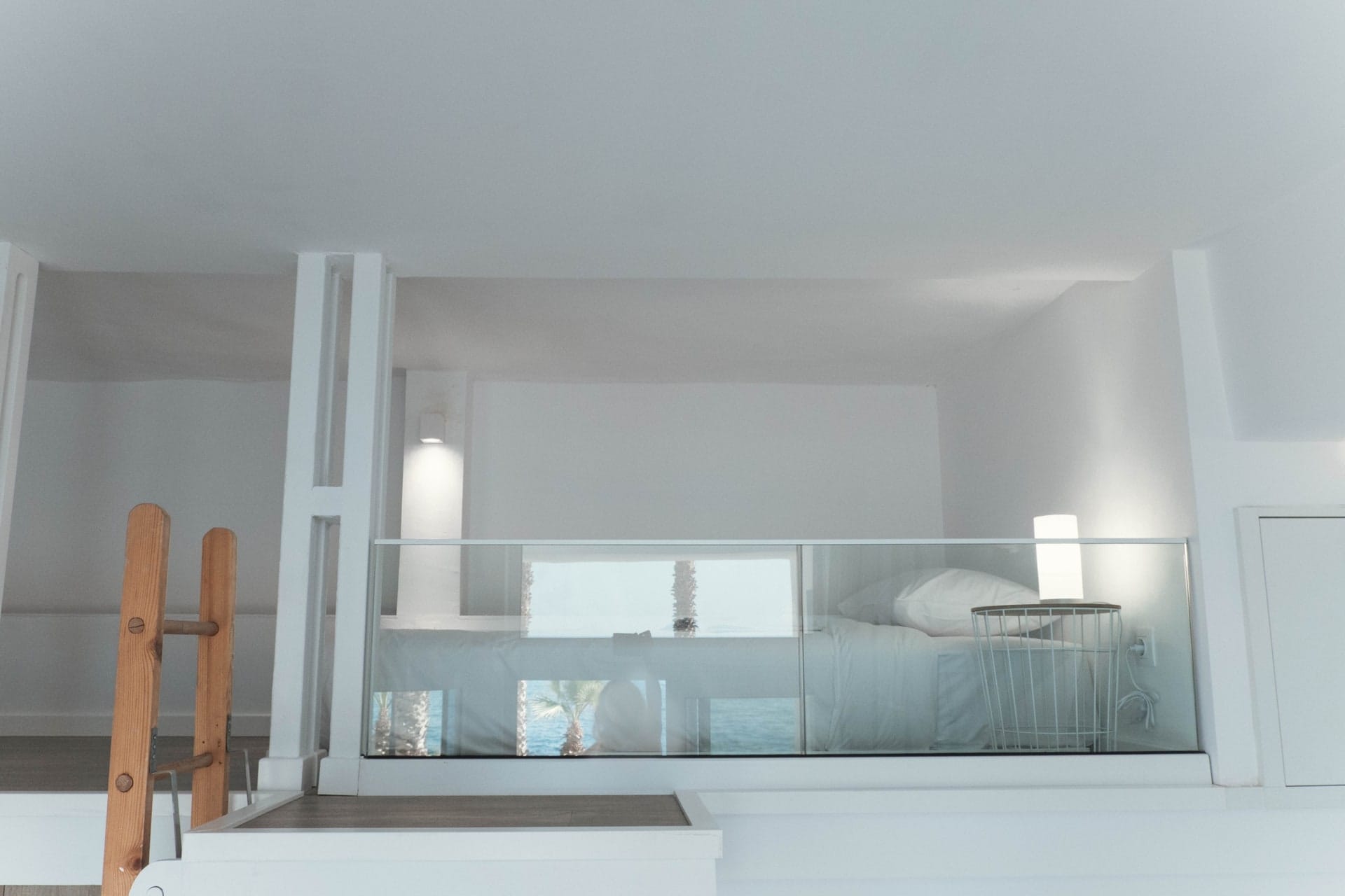 Single bed on the upper level behind a glass balustrade