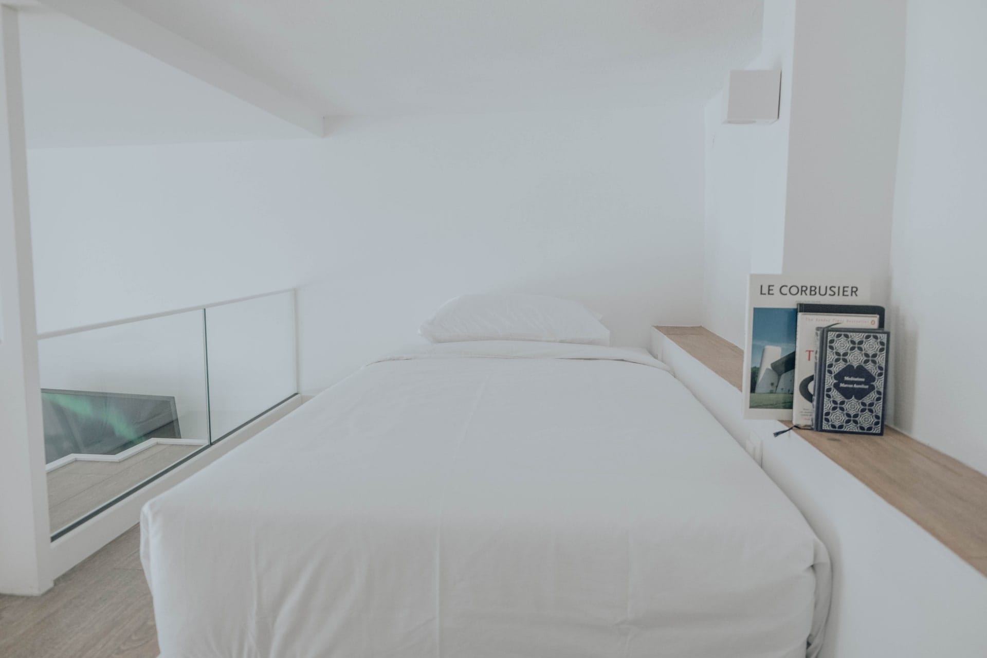 Upper level bed with books stacked on the ledge